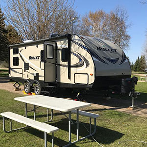 Fifth-Wheel Camper parked next to a picnic table | RV Camping