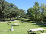 Numerous campsites with picinic tables and fire rings at Oak Park Kampground