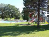 Distant shot of the playgrounds near the gated pool area at Oak Park Kampground