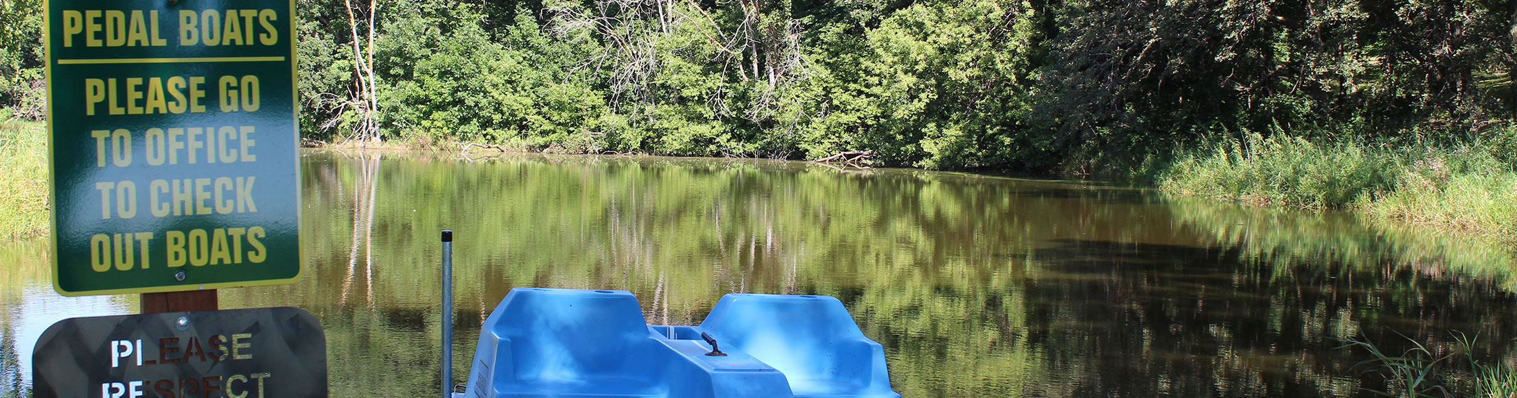 Pond with dock and paddle boat at Oak Park Kampground