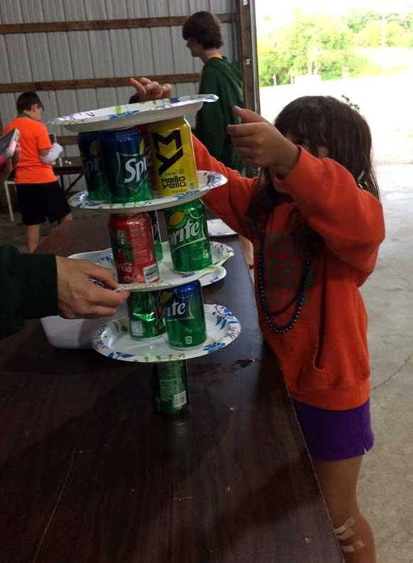 Kids building a tower out of pop cans and paper plates